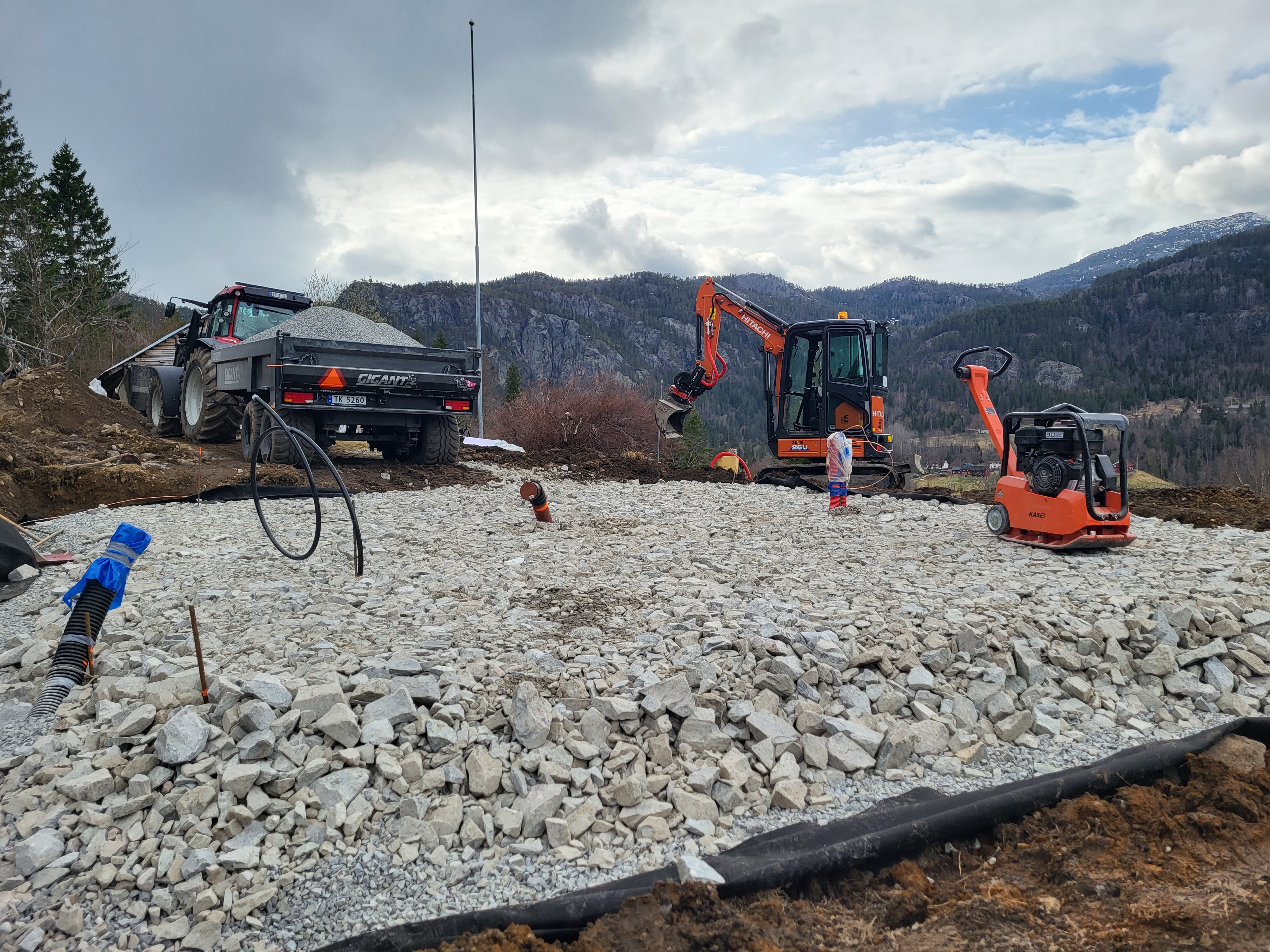 Gravemaskin i arbeid med tomtegraving